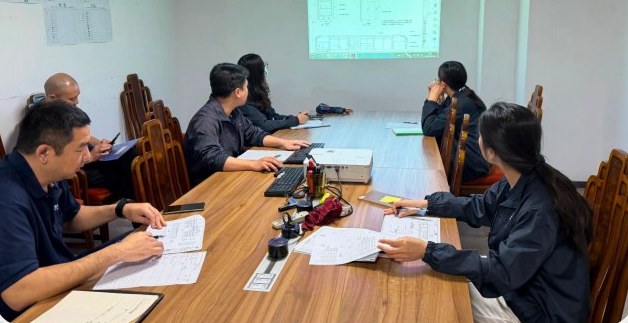 Project team reviewing a furniture schedule and drawings in a meeting