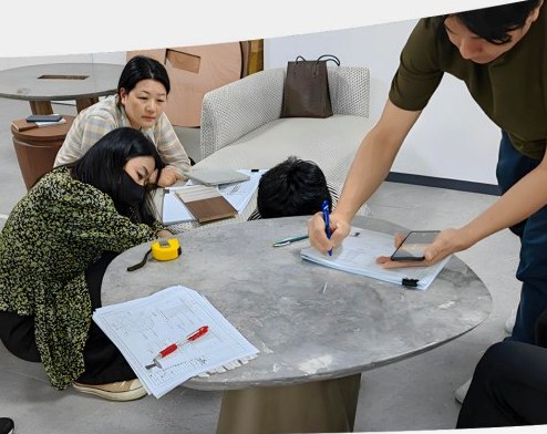 Table details and paper drawings reviewed beside seating