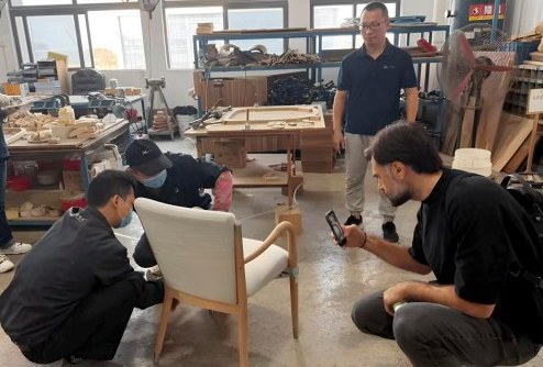 A furniture chair sample inspected closely in a workshop