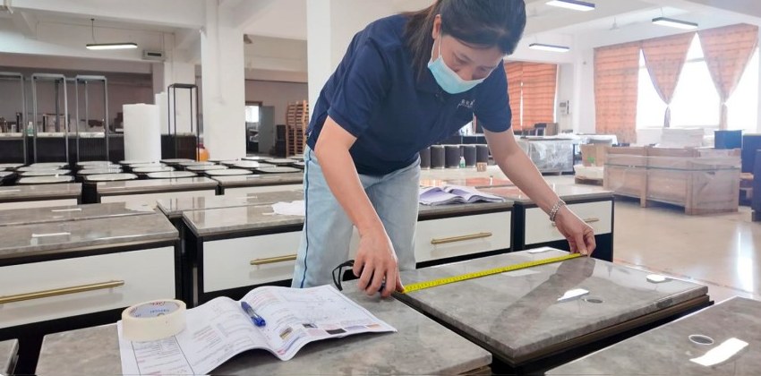 A tabletop being measured during a furniture inspection