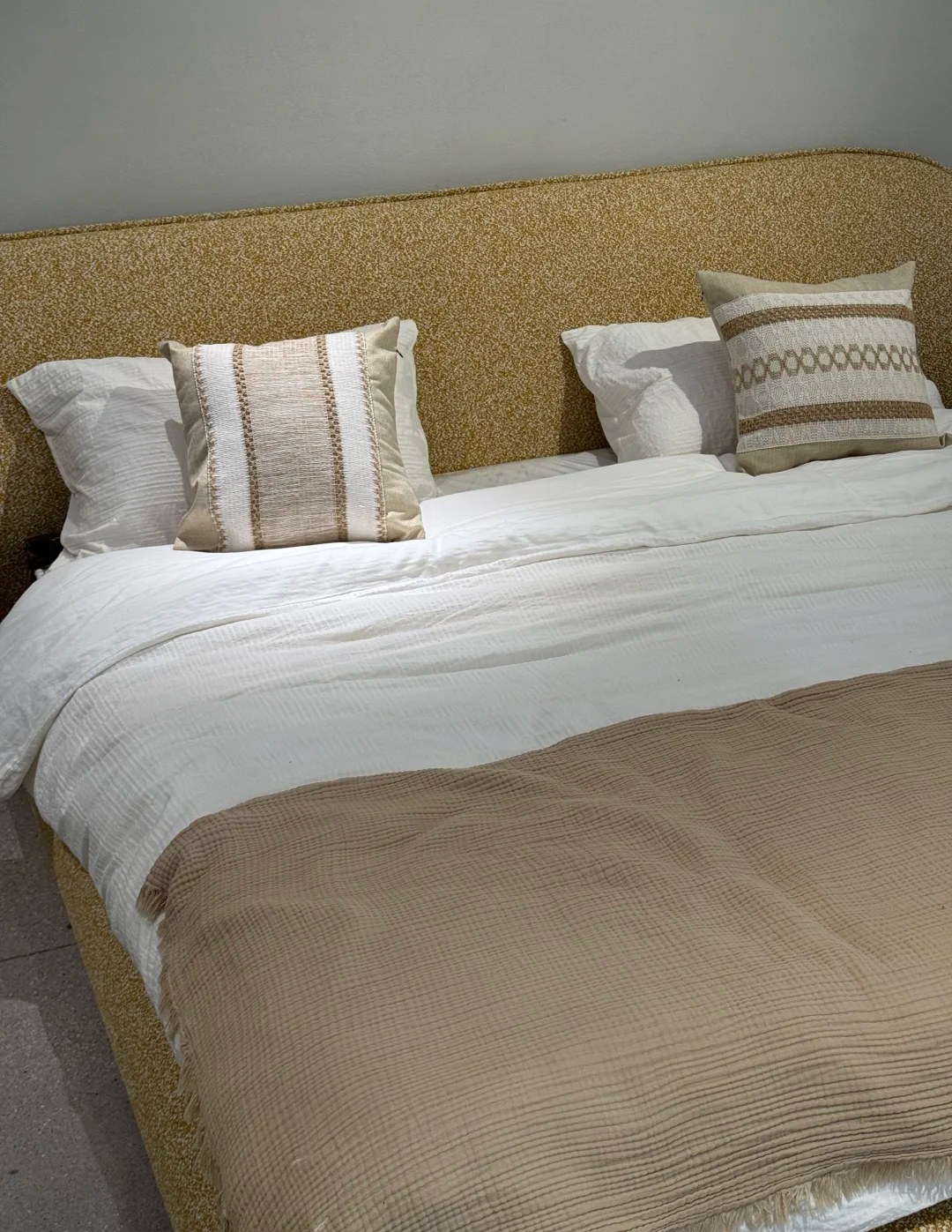 Upholstered bed with layered textiles