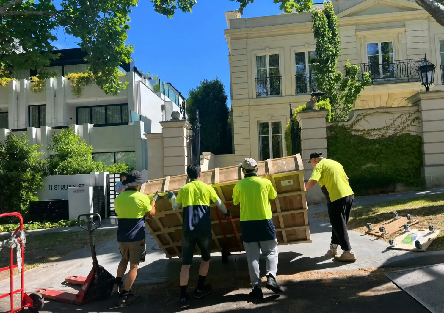 Delivery crew carrying a crate to the front gate