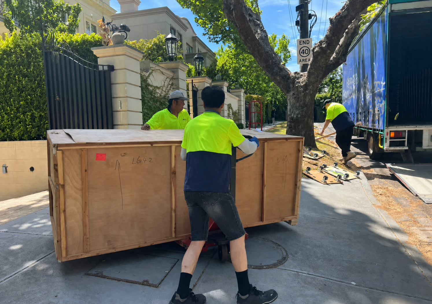 Delivery crew carrying a Ratahome crate through a residential gate