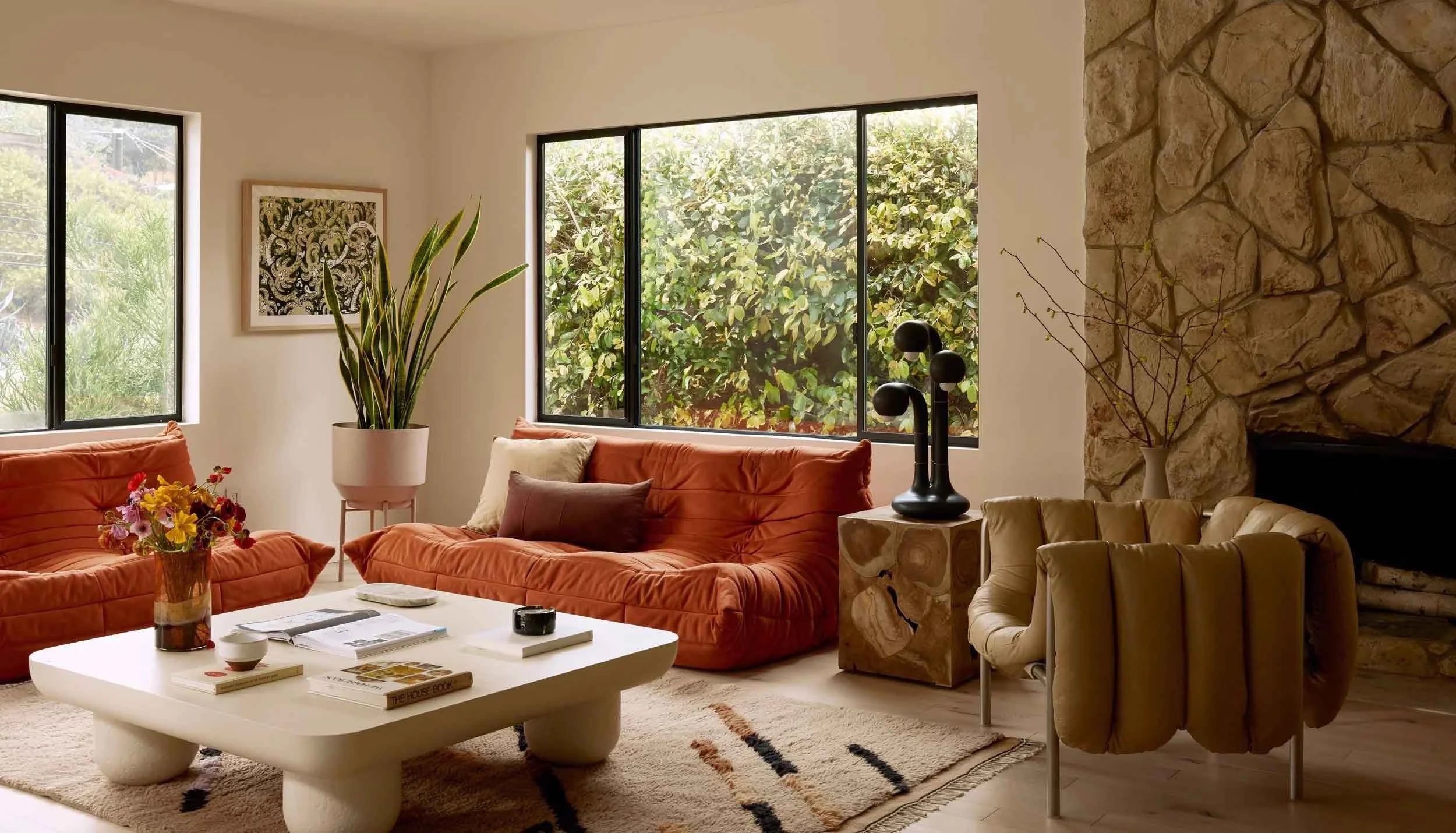 Sunlit living room with soft neutral sofas and sculptural furniture