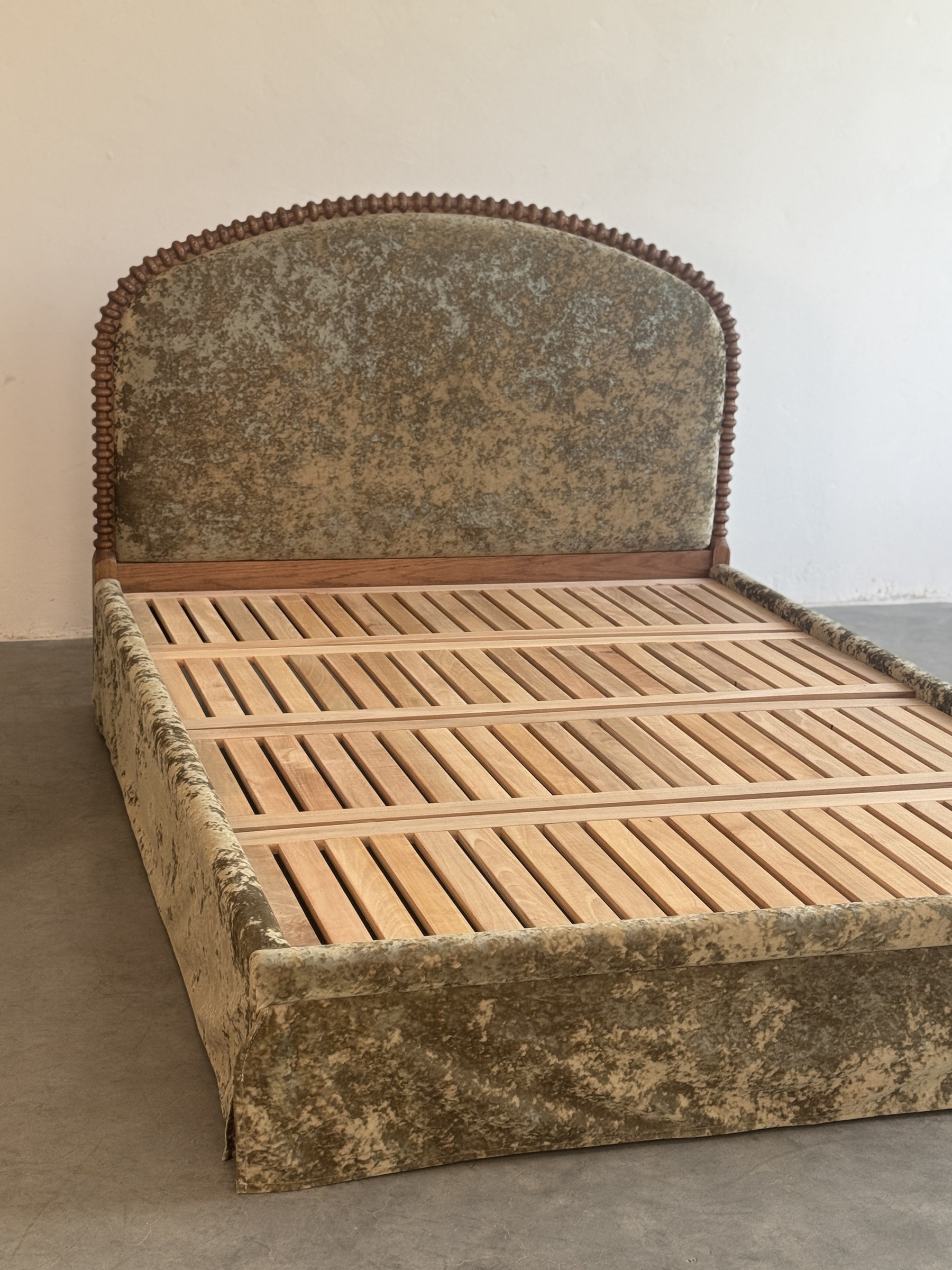 Upholstered bed with solid wood slatted frame in production