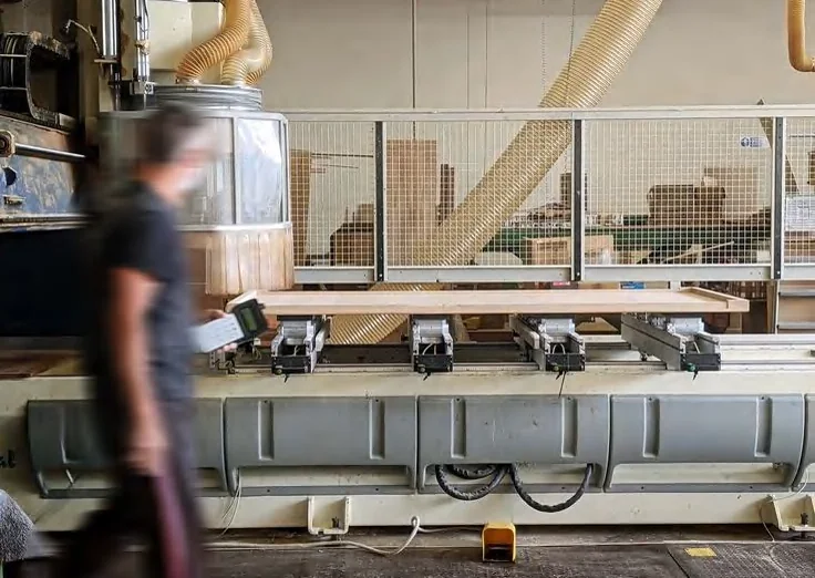 Technician running components through the CNC drilling line