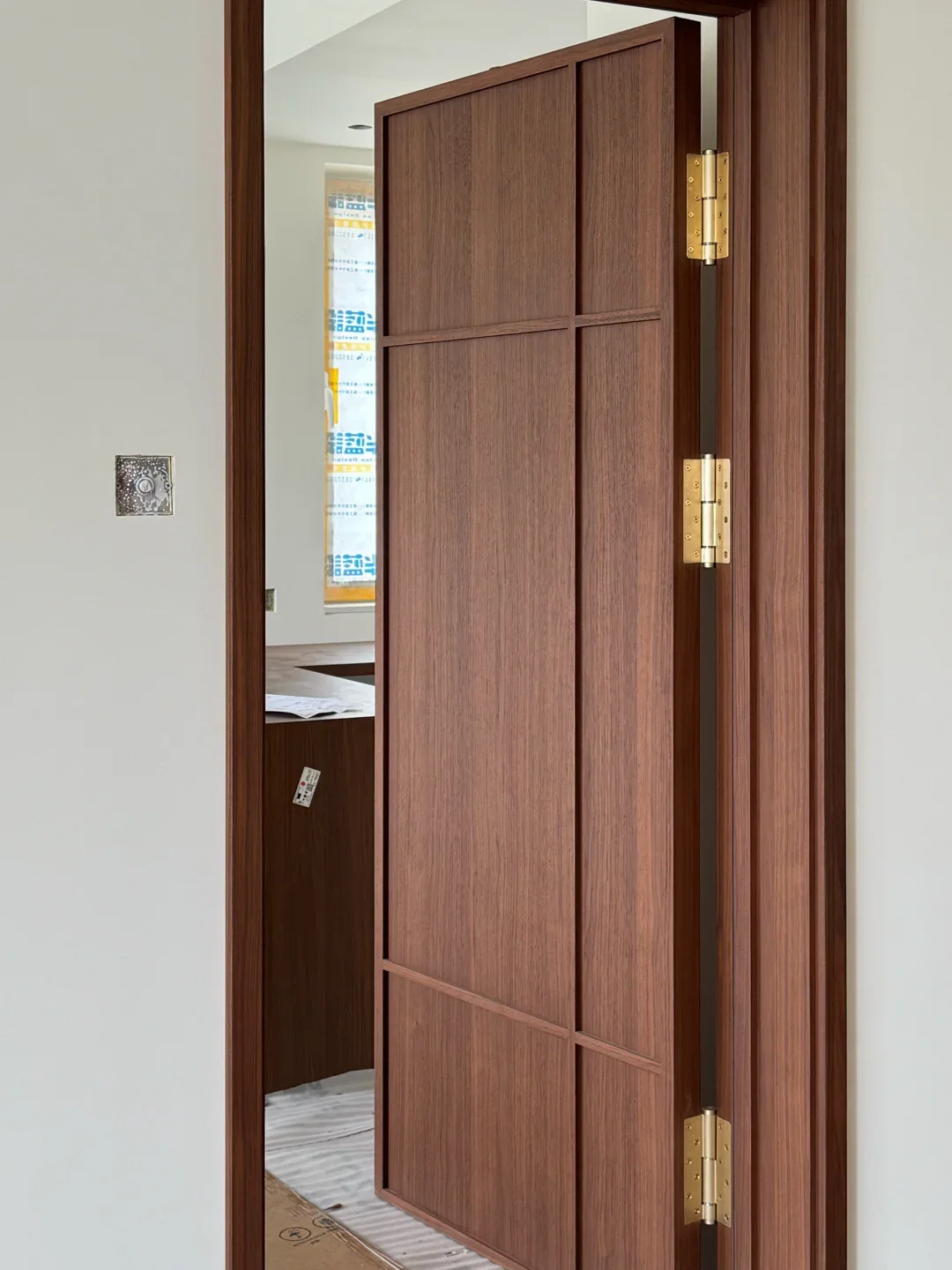 Framed walnut door with brass hinges