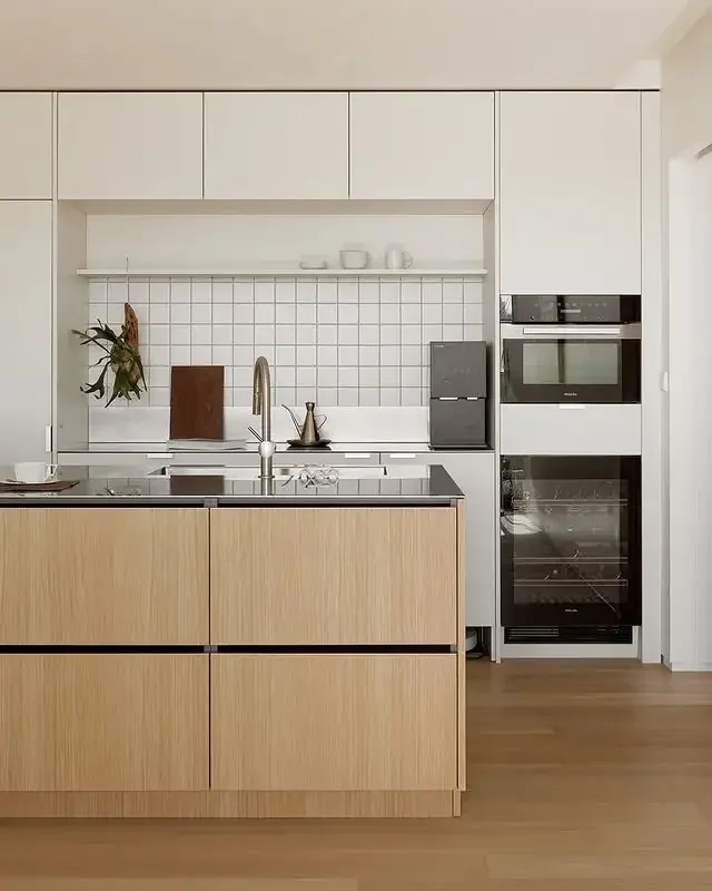 Built-in ovens and wine storage in a white and oak kitchen