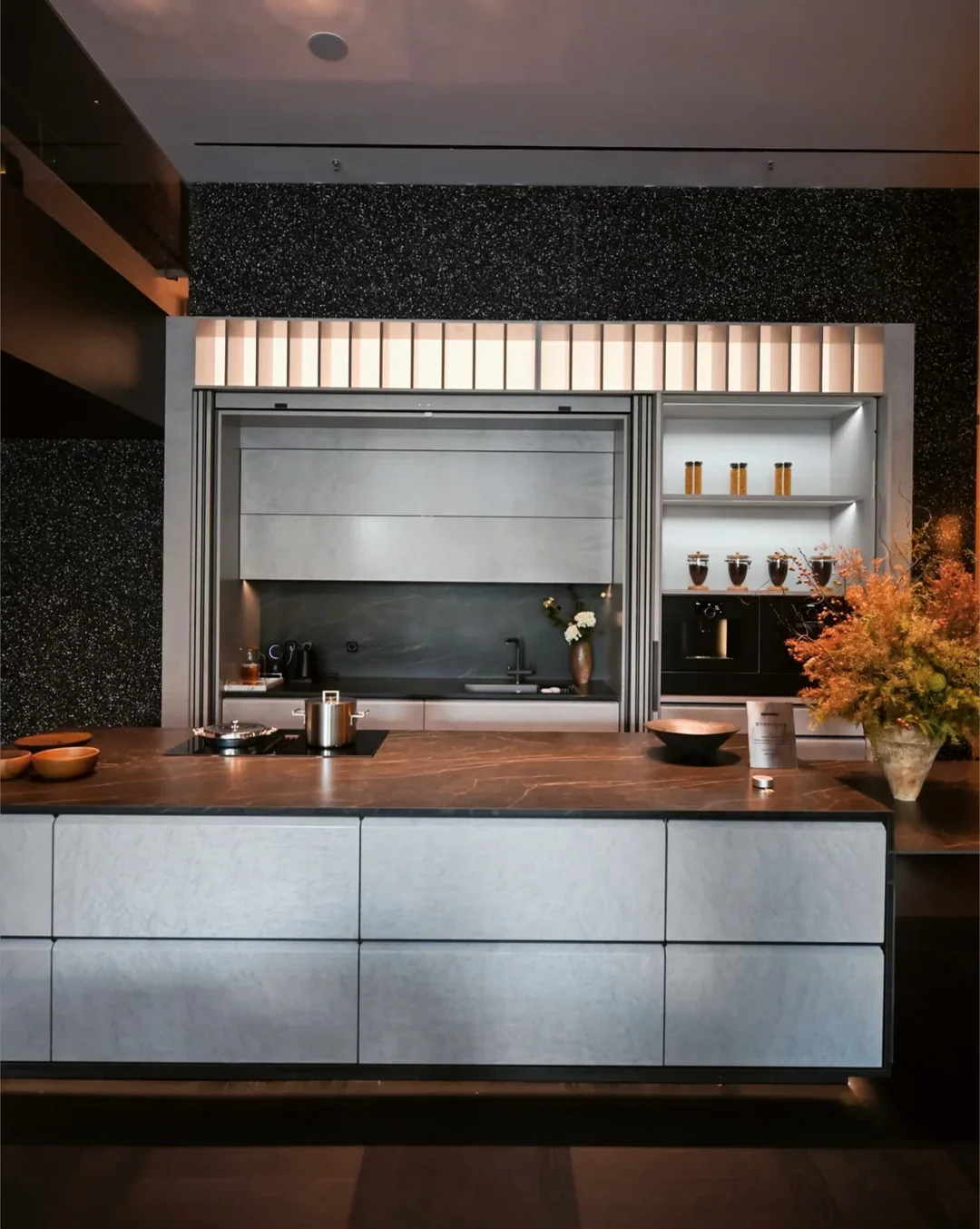 Pocket-door kitchen with backlit fluted glass and stone island