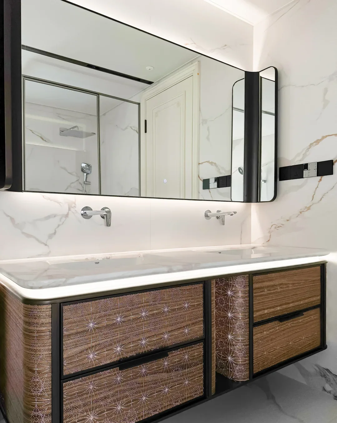 Vanity with textured dark fronts and lit mirror