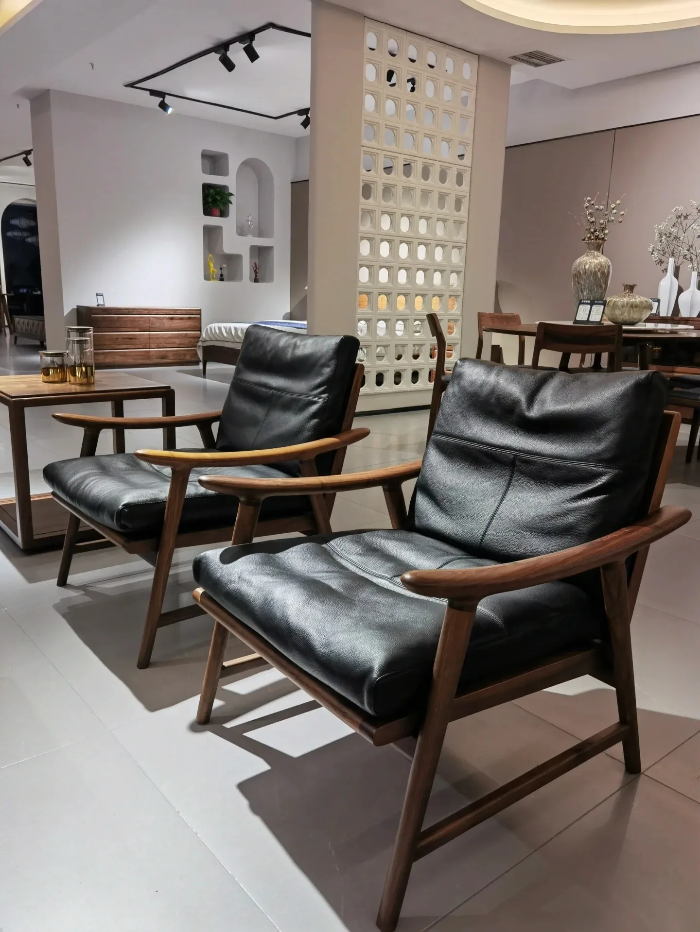 Black leather lounge chairs with exposed wood frames