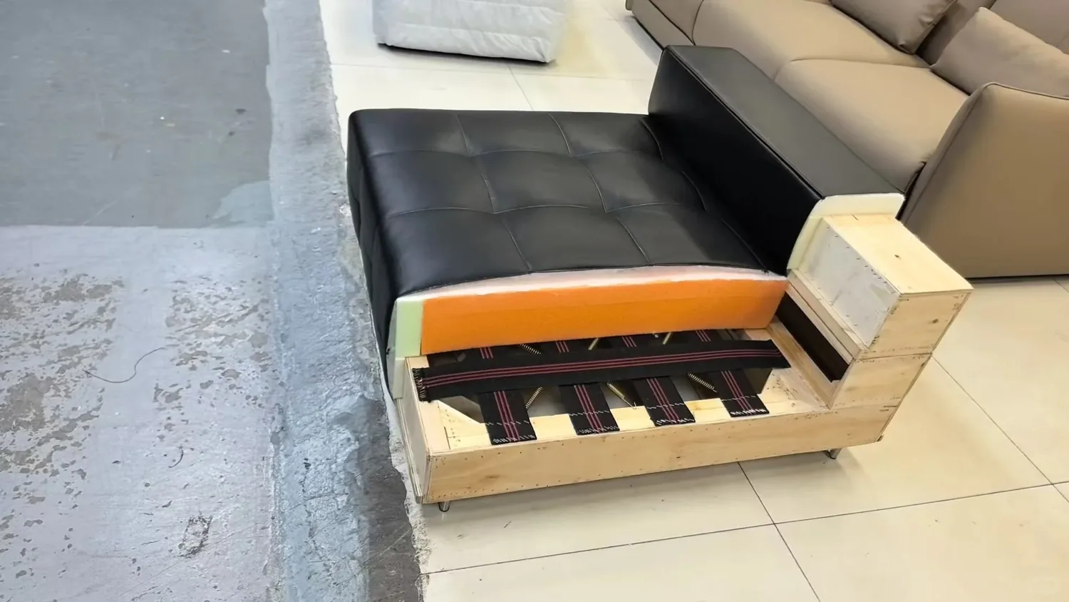 Real sofa seat cutaway showing upholstery, layered foam, woven webbing and a timber base