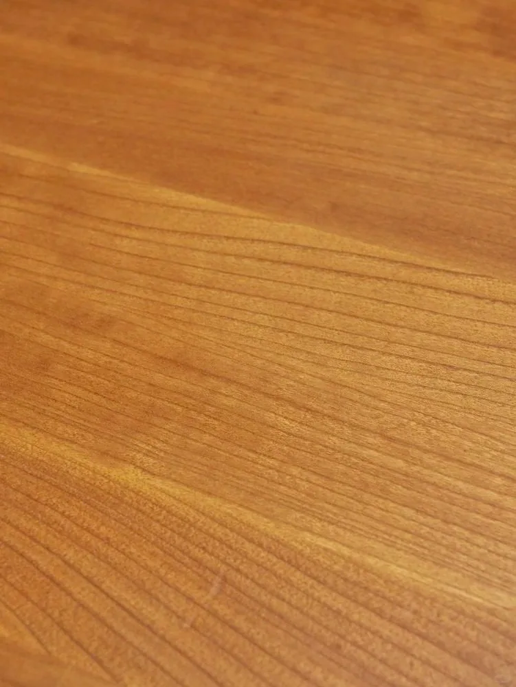 Close-up detail of warm natural wood grain on a tabletop.