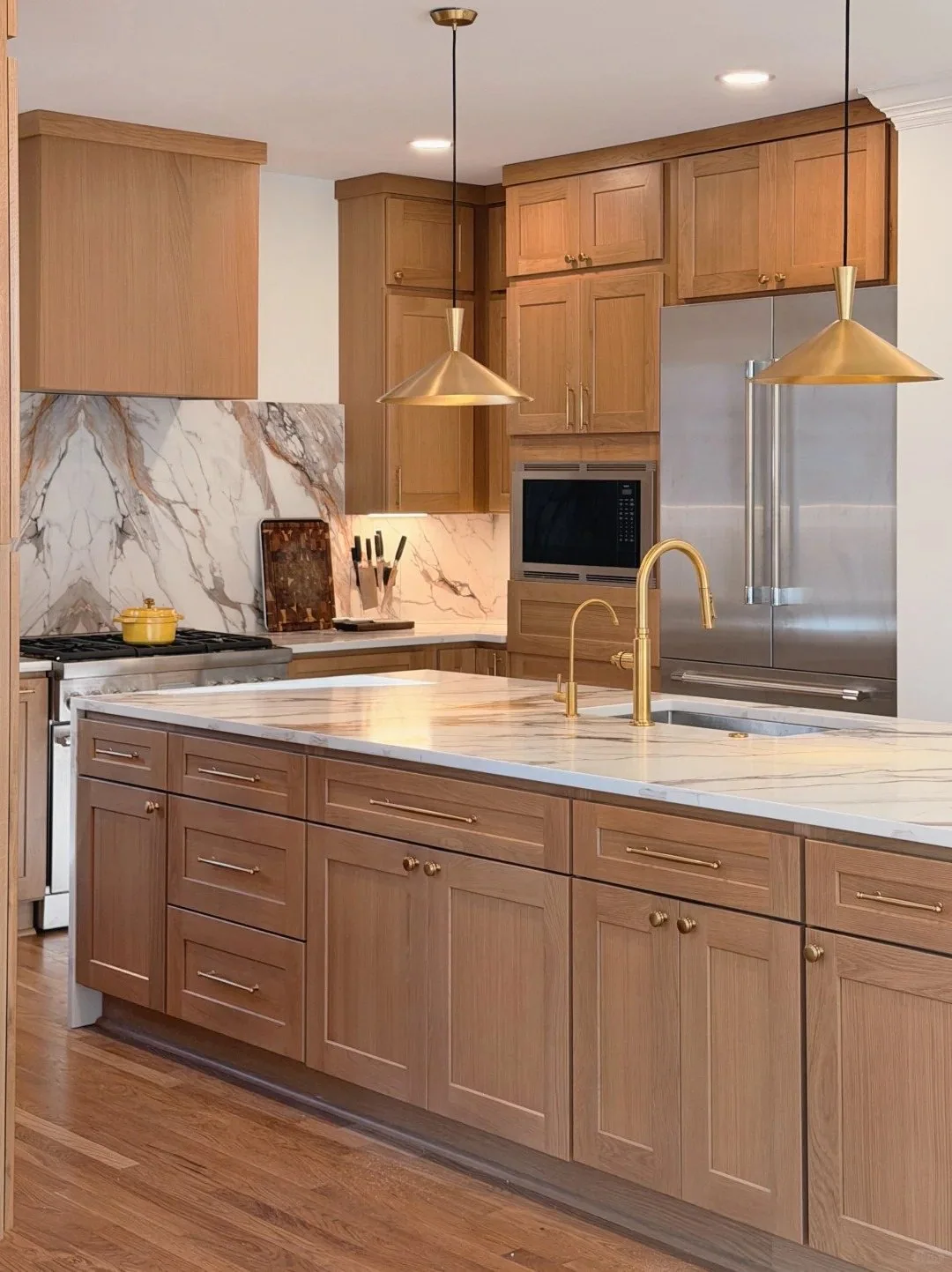 Warm wood custom kitchen cabinetry with island, stone worktops and integrated appliances