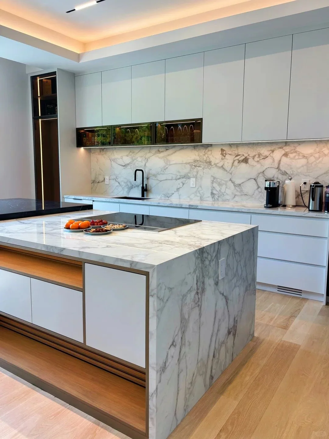 Contemporary white custom kitchen cabinetry with stone island and integrated lighting
