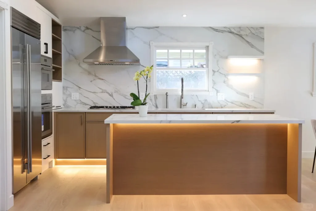 Finished custom kitchen showing integrated appliances, stone surfaces, lighting and project-specific cabinetry