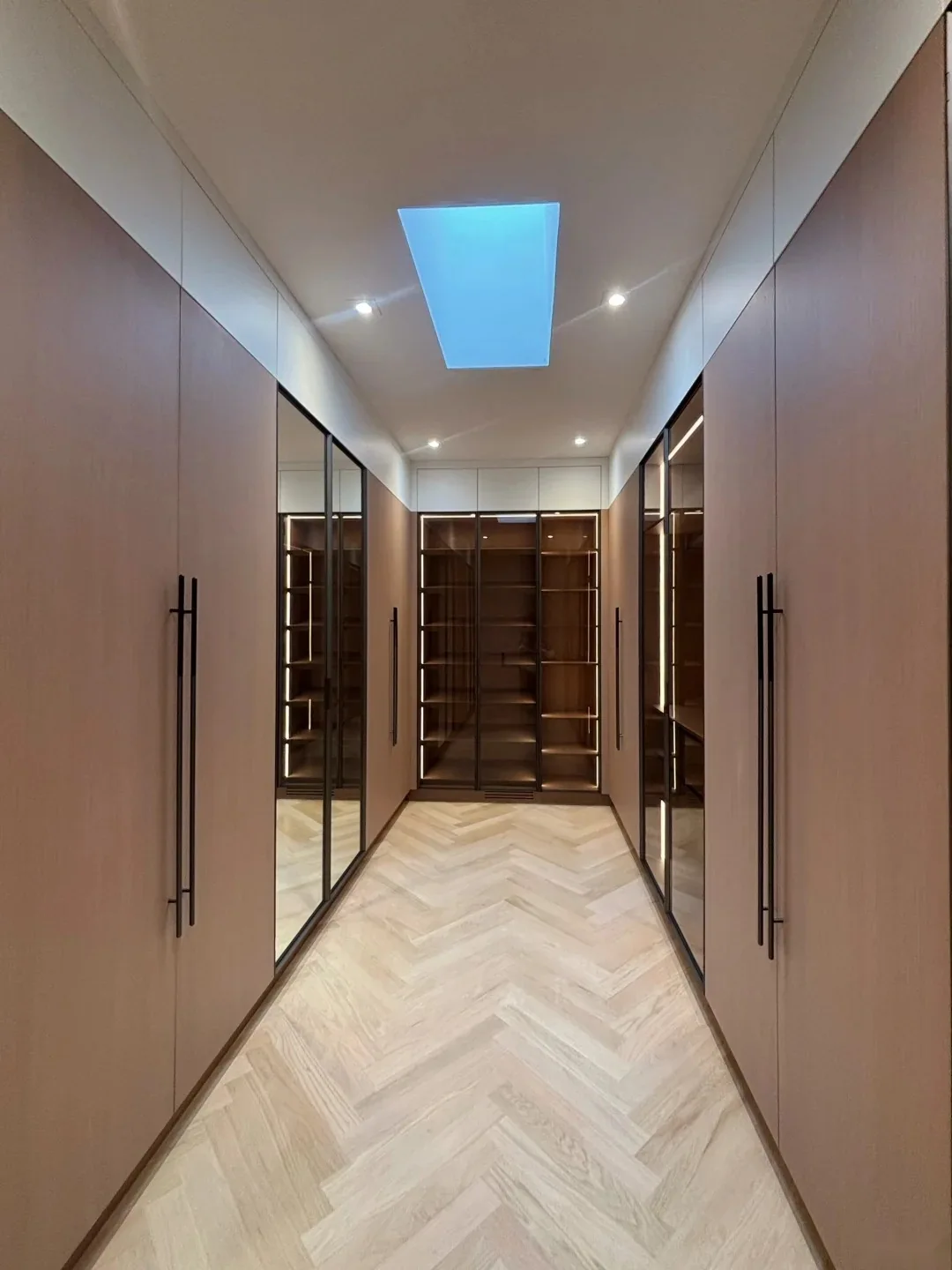 Floor-to-ceiling walk-in wardrobe with custom door sizes, integrated mirrors, glass sections and lighting