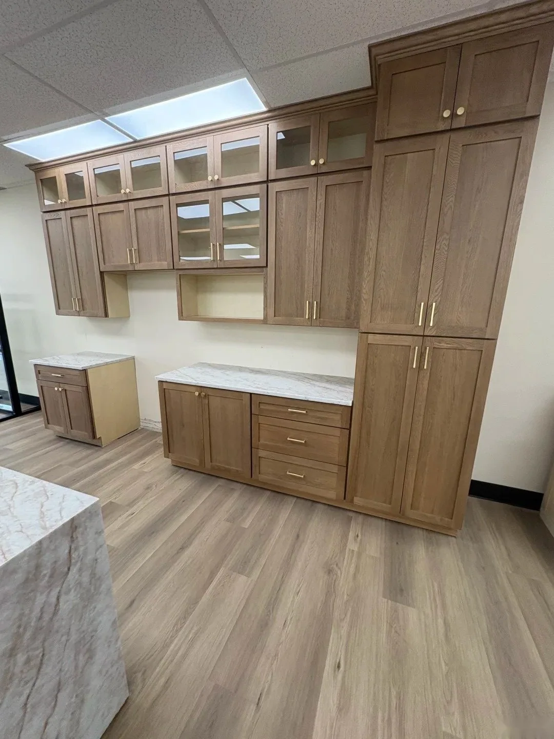 Completed custom cabinetry wall with tall storage, drawers and stone worktops