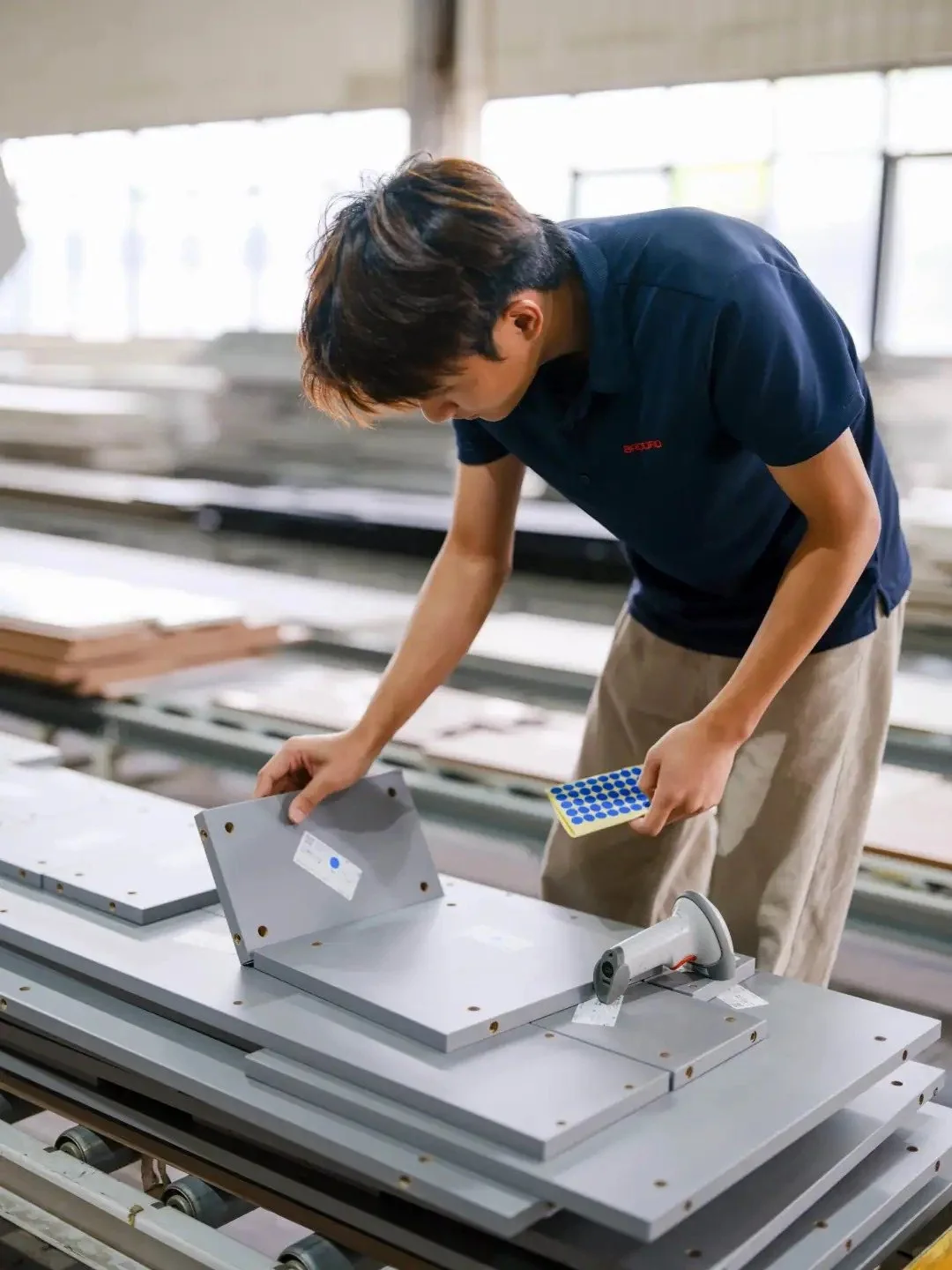 Factory worker inspecting cabinet components during production