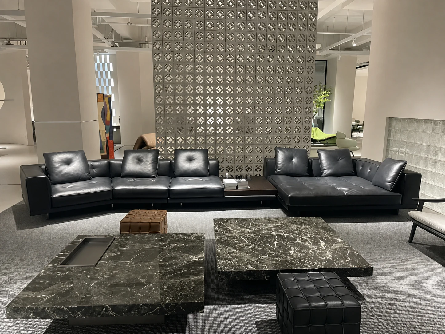 Black leather sectional and stone coffee tables in a Foshan showroom