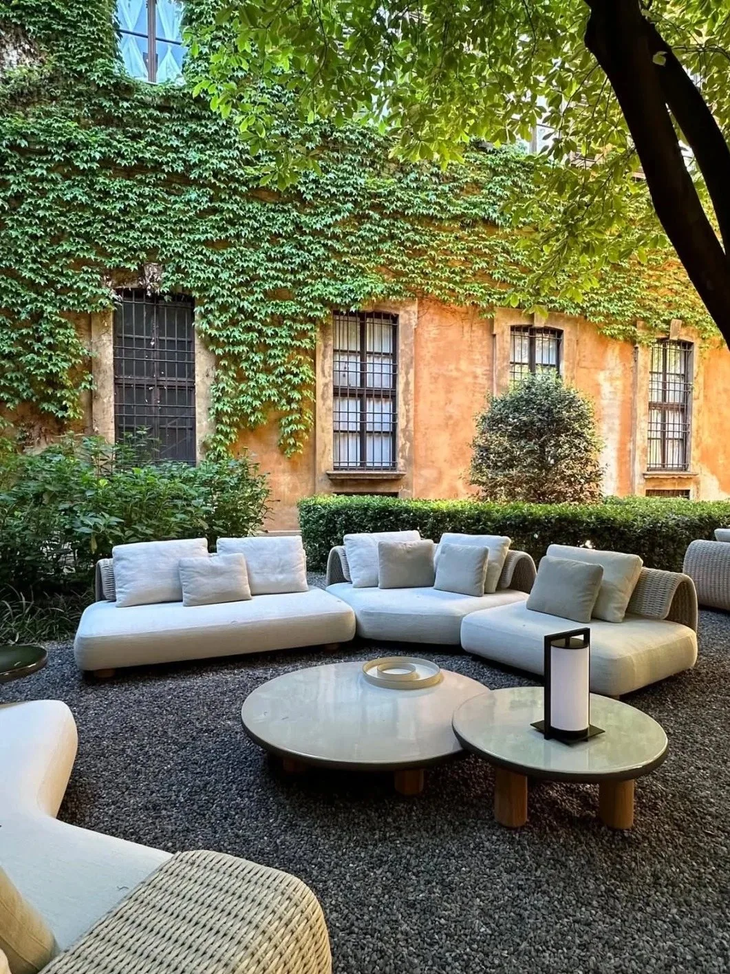 Organic modern outdoor sectional around sculptural low coffee tables