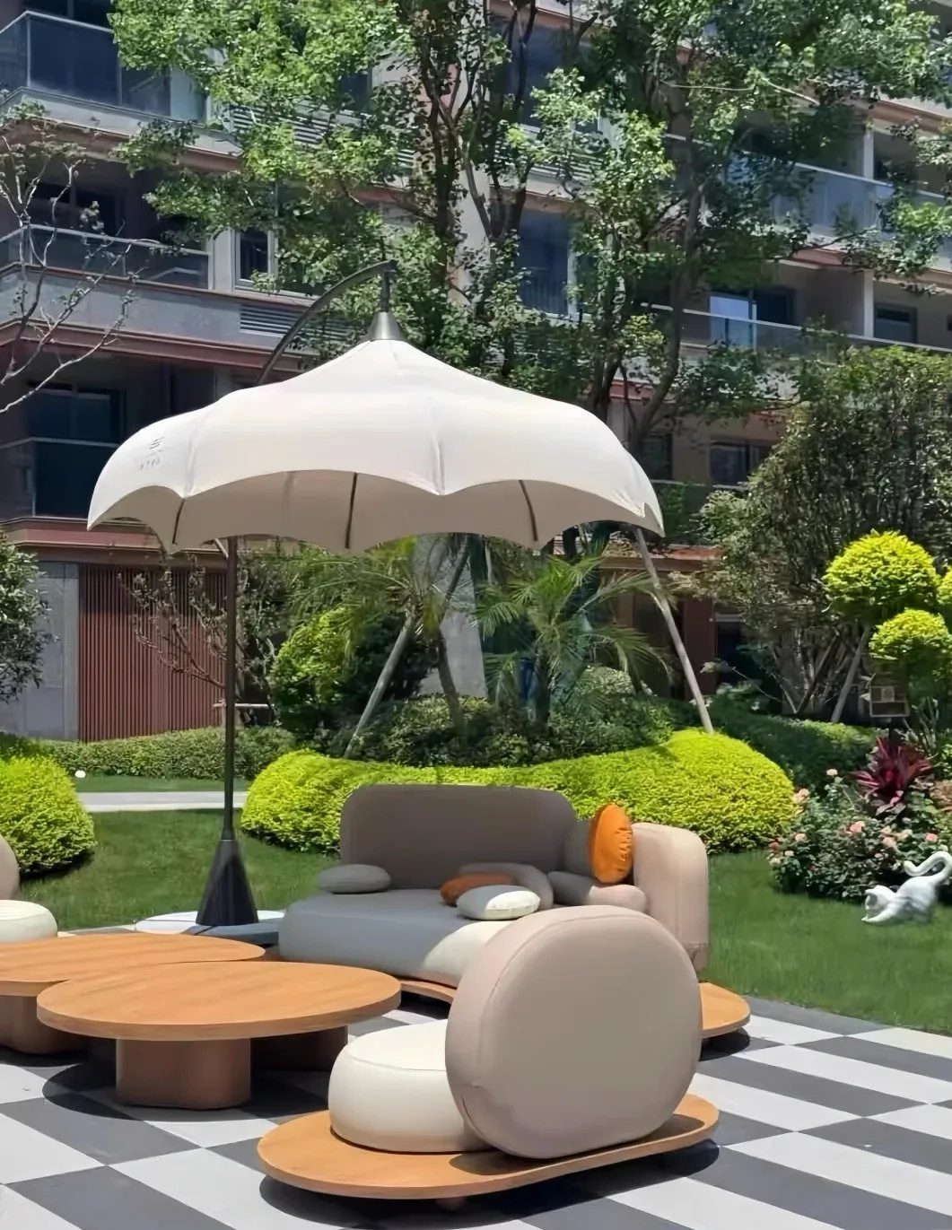 Modern outdoor lounge chairs and low tables under a large garden umbrella