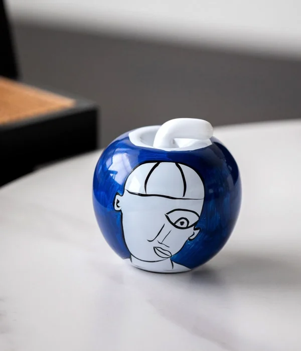 Hand-Painted Abstract Face Blue Glass Apple Ornament in blue — in a room setting