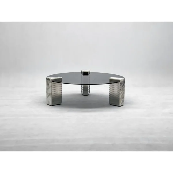 Round Glass Coffee Table on Marble and Chrome Column Base in black — in a room setting
