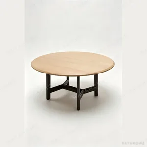 Alex Ash Round Dining Table on Red Steel Base in natural oak — in a room setting