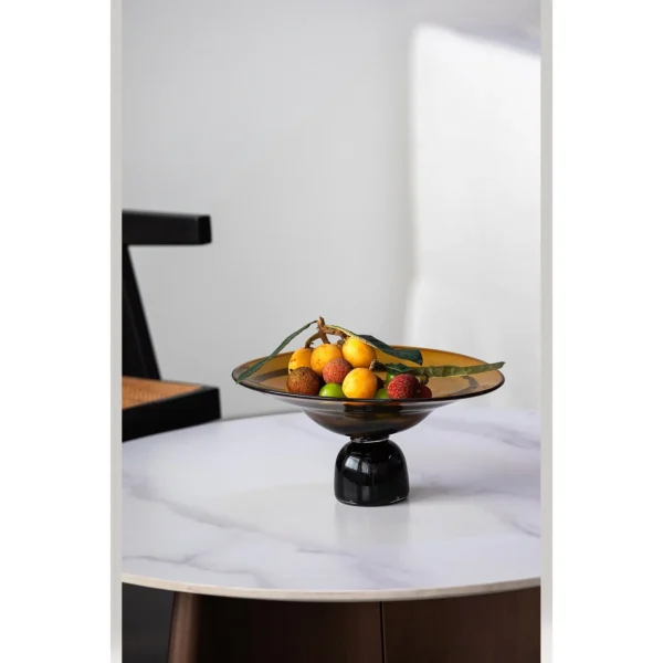 Amber and Black Hand-Made Footed Glass Fruit Bowl in clay — in a room setting