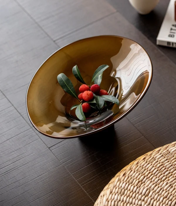 Amber and Black Hand-Made Footed Glass Fruit Bowl in clay — in a room setting