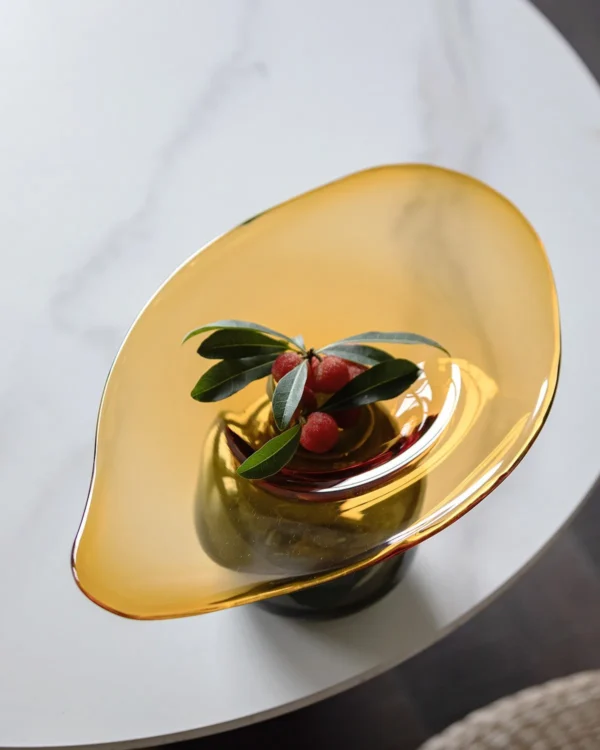 Amber and Black Hand-Made Footed Glass Fruit Bowl in clay — in a room setting