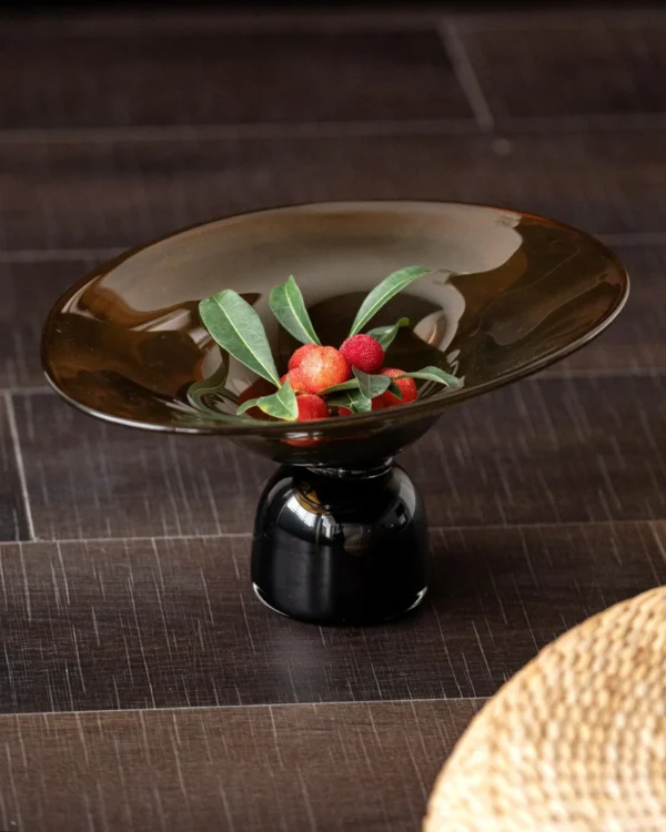 Amber and Black Hand-Made Footed Glass Fruit Bowl in clay — in a room setting