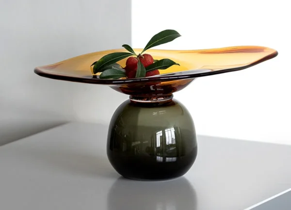Amber and Black Hand-Made Footed Glass Fruit Bowl in clay — in a room setting