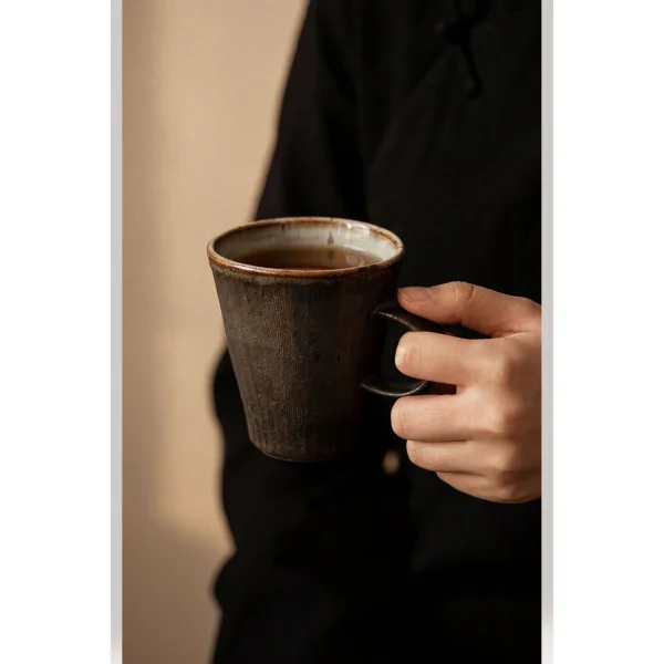 Artist Collaboration Black Glaze Ribbed Stoneware Mugs in black — in a room setting