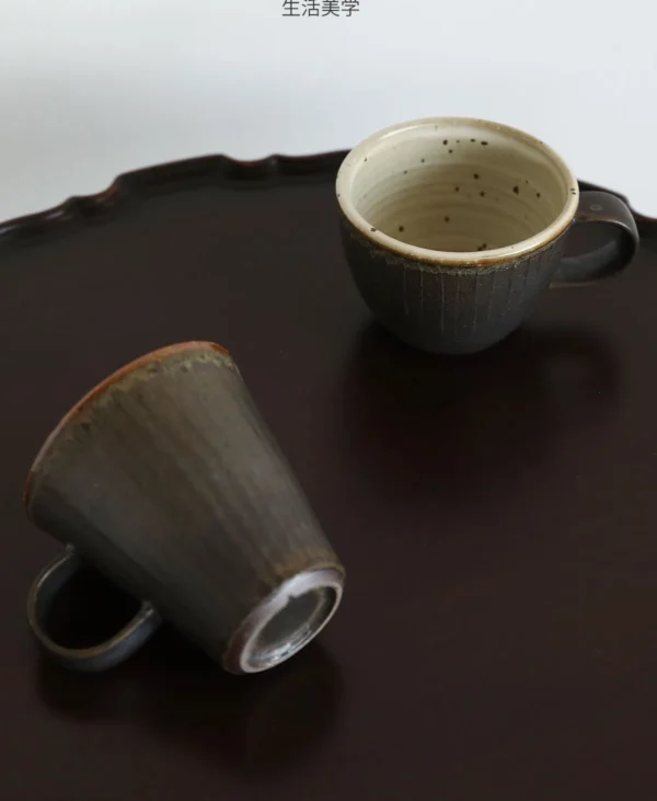 Artist Collaboration Black Glaze Ribbed Stoneware Mugs in black — in a room setting