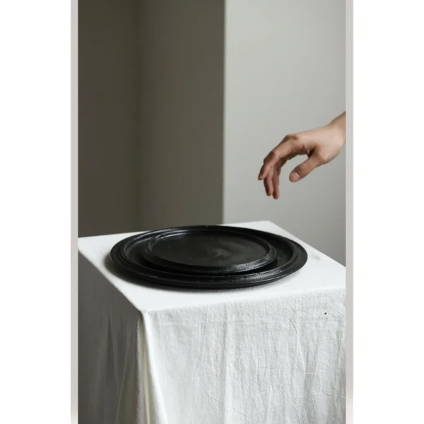 Handmade Black Swirl Stoneware Plates in black — in a room setting