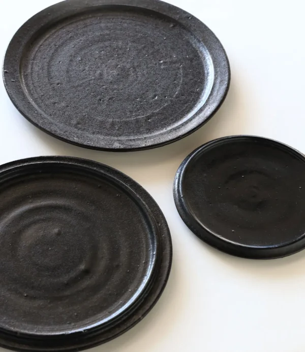 Handmade Black Swirl Stoneware Plates in black — in a room setting