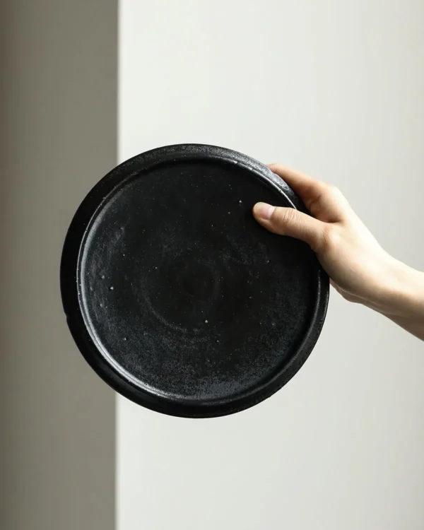 Handmade Black Swirl Stoneware Plates in black — in a room setting