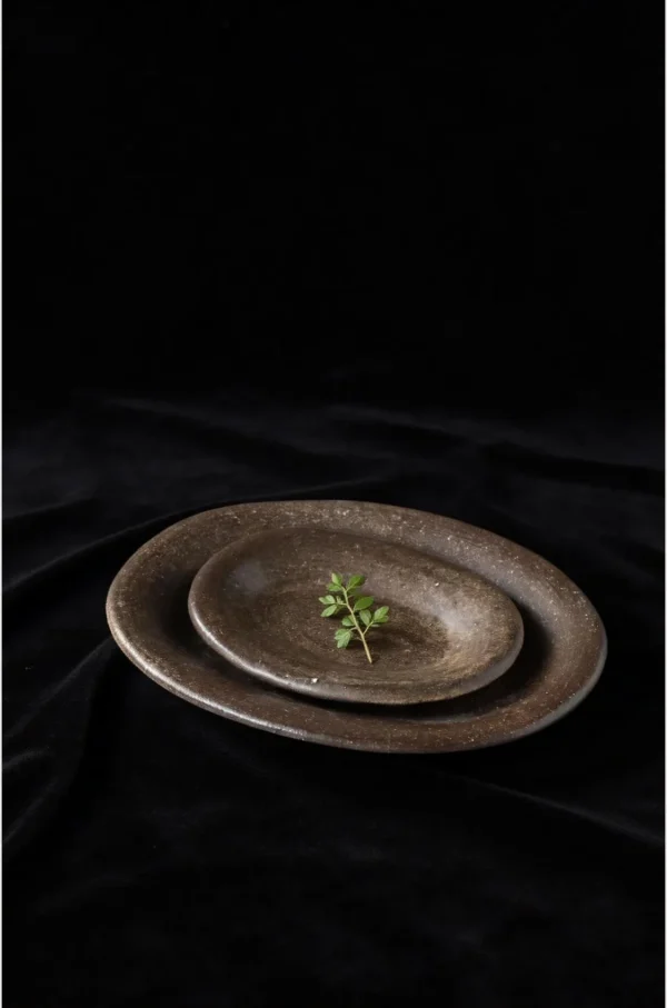 Artist Collaboration Brown Sand Glaze Oval Stoneware Plates in clay — in a room setting
