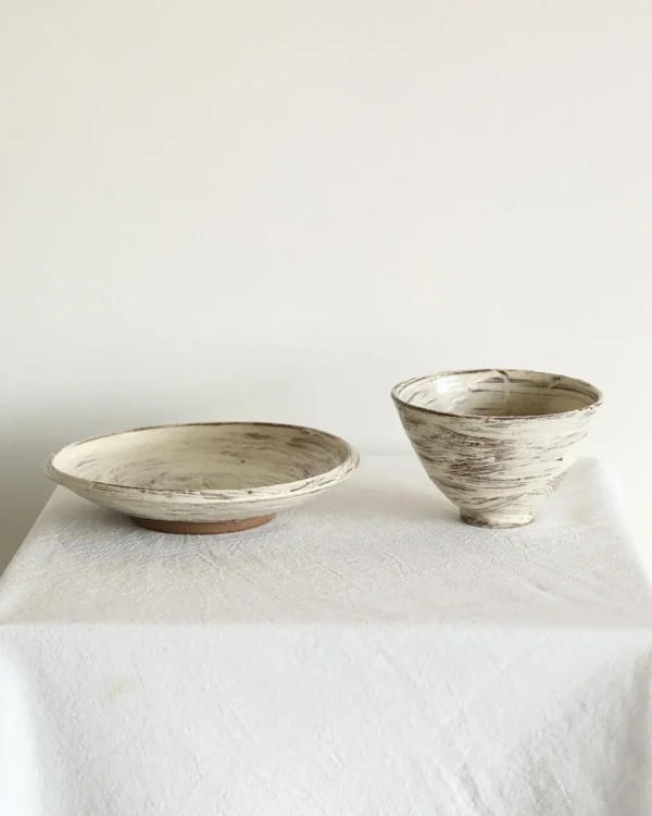Artist Collaboration Brushed Ceramic Conical Bowl and Plate in ivory — in a room setting