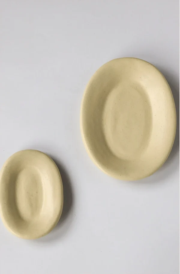 Artist Collaboration Oval Ceramic Plates in Pale Straw Glaze — in a room setting