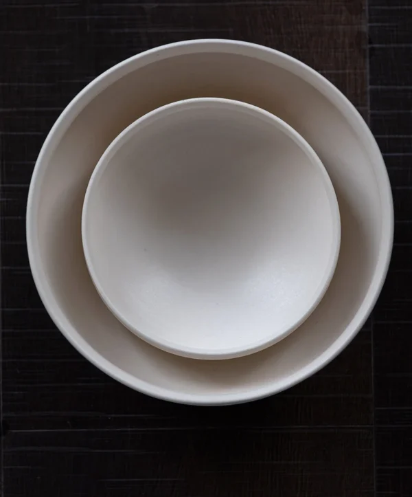 Artist Collaboration Folded-Edge Cone-Base Ceramic Bowls in ivory — in a room setting