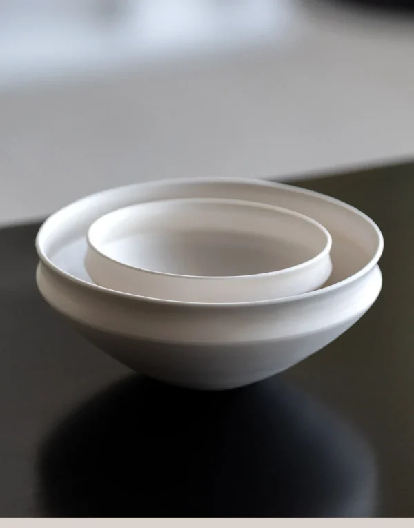 Artist Collaboration Folded-Edge Cone-Base Ceramic Bowls in ivory — in a room setting