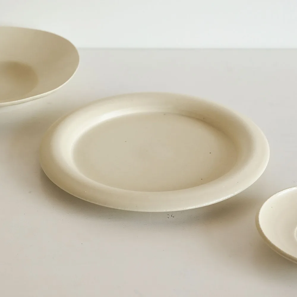Artist Collaboration Off-White Ceramic Plates and Bowls Set in oatmeal — front view