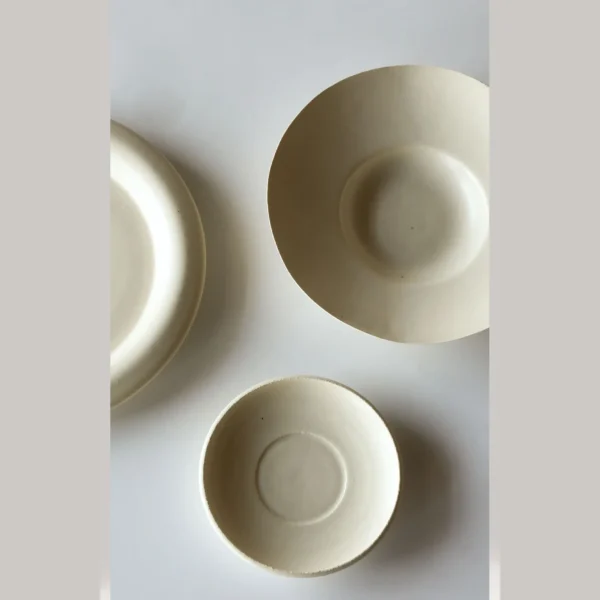 Artist Collaboration Off-White Ceramic Plates and Bowls Set in oatmeal — in a room setting