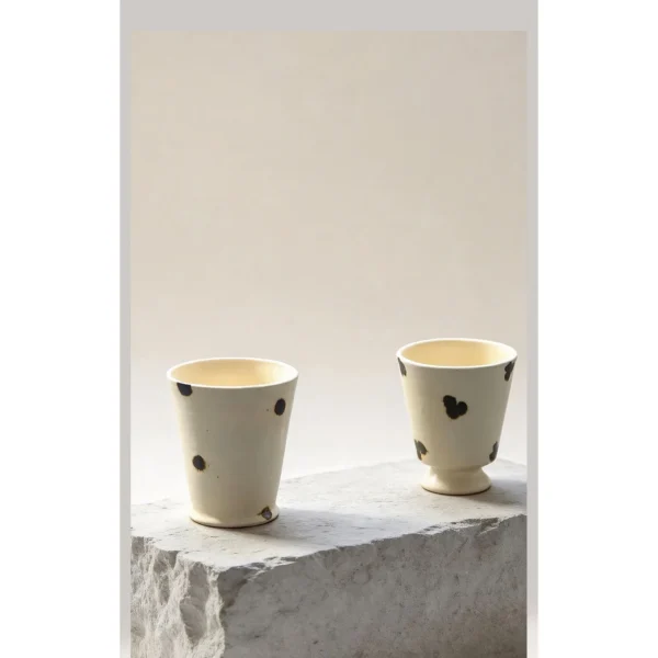 Artist Collaboration Dotted Stoneware Latte Cup, Cream in oatmeal — in a room setting