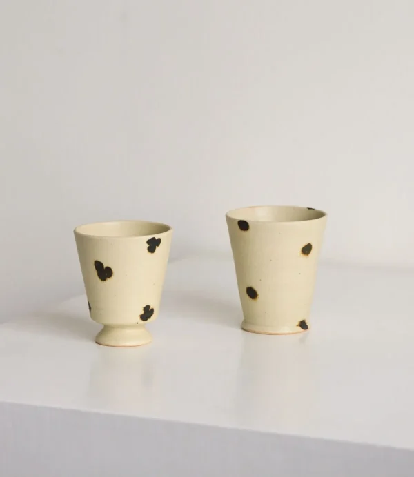 Artist Collaboration Dotted Stoneware Latte Cup, Cream in oatmeal — in a room setting