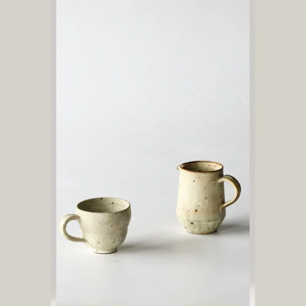 Artist Collaboration Stoneware Coffee Mug and Jug in olive — in a room setting