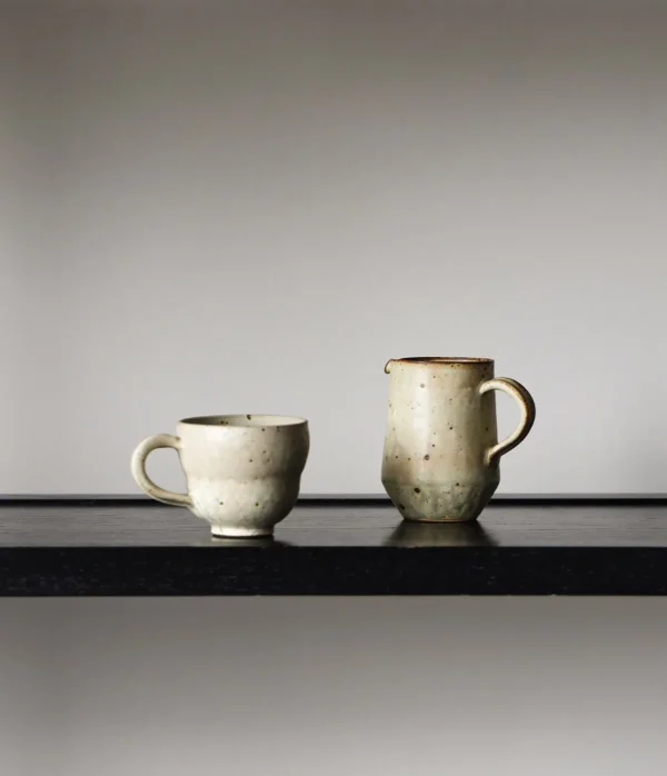 Artist Collaboration Stoneware Coffee Mug and Jug in olive — in a room setting